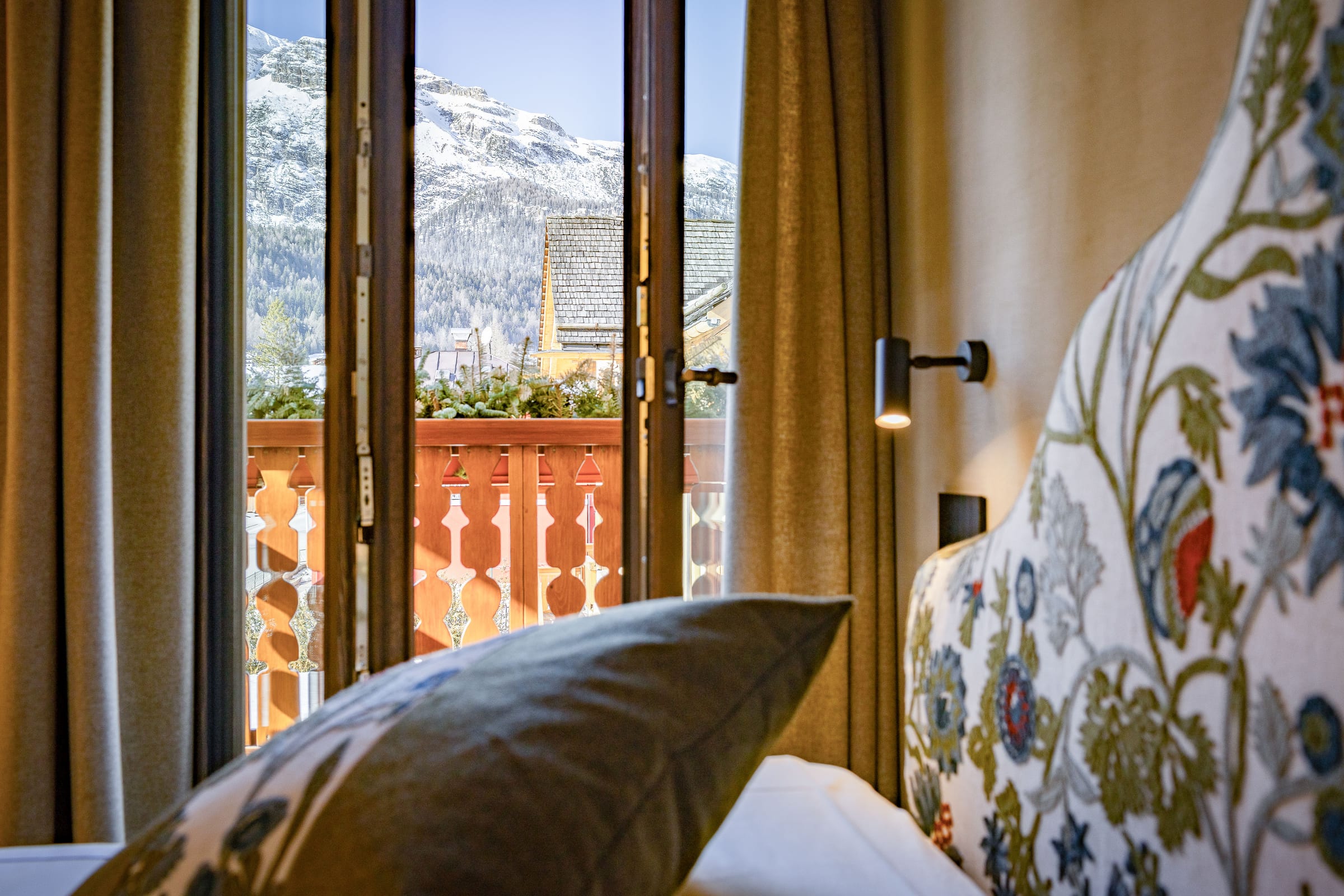 Le Dolomiti incorniciate dalla finestra accanto al letto della Tofana