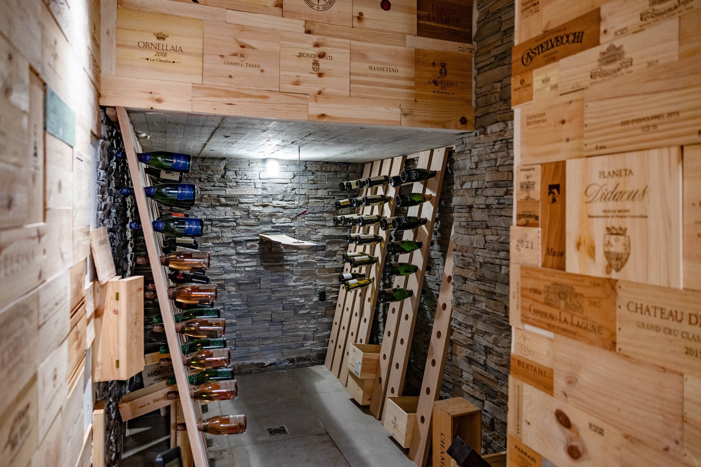 Etichette della cantina: Pomerol, Masseto, Ceretto allineate negli scaffali