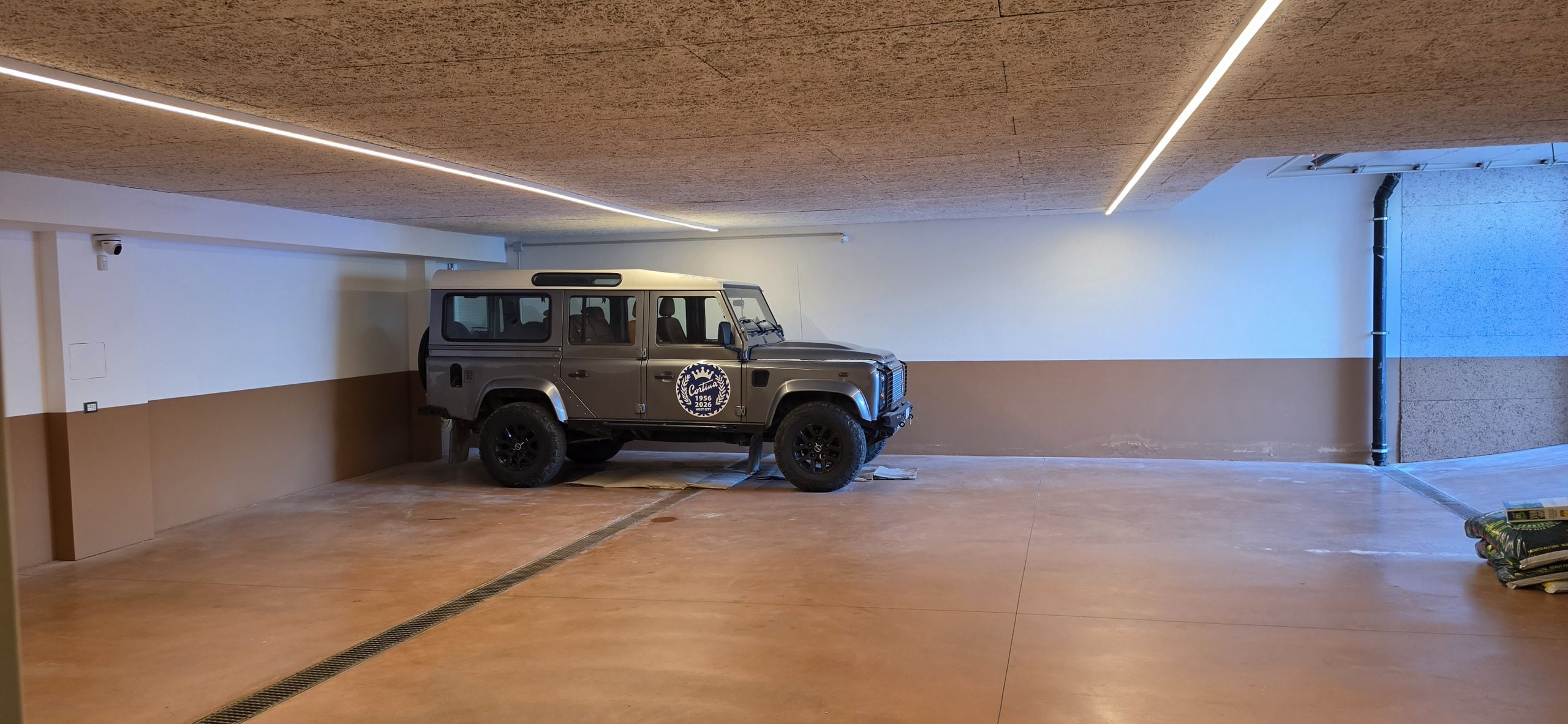 Land Rover Defender parked in the villa's garage beside a wide open parking floor