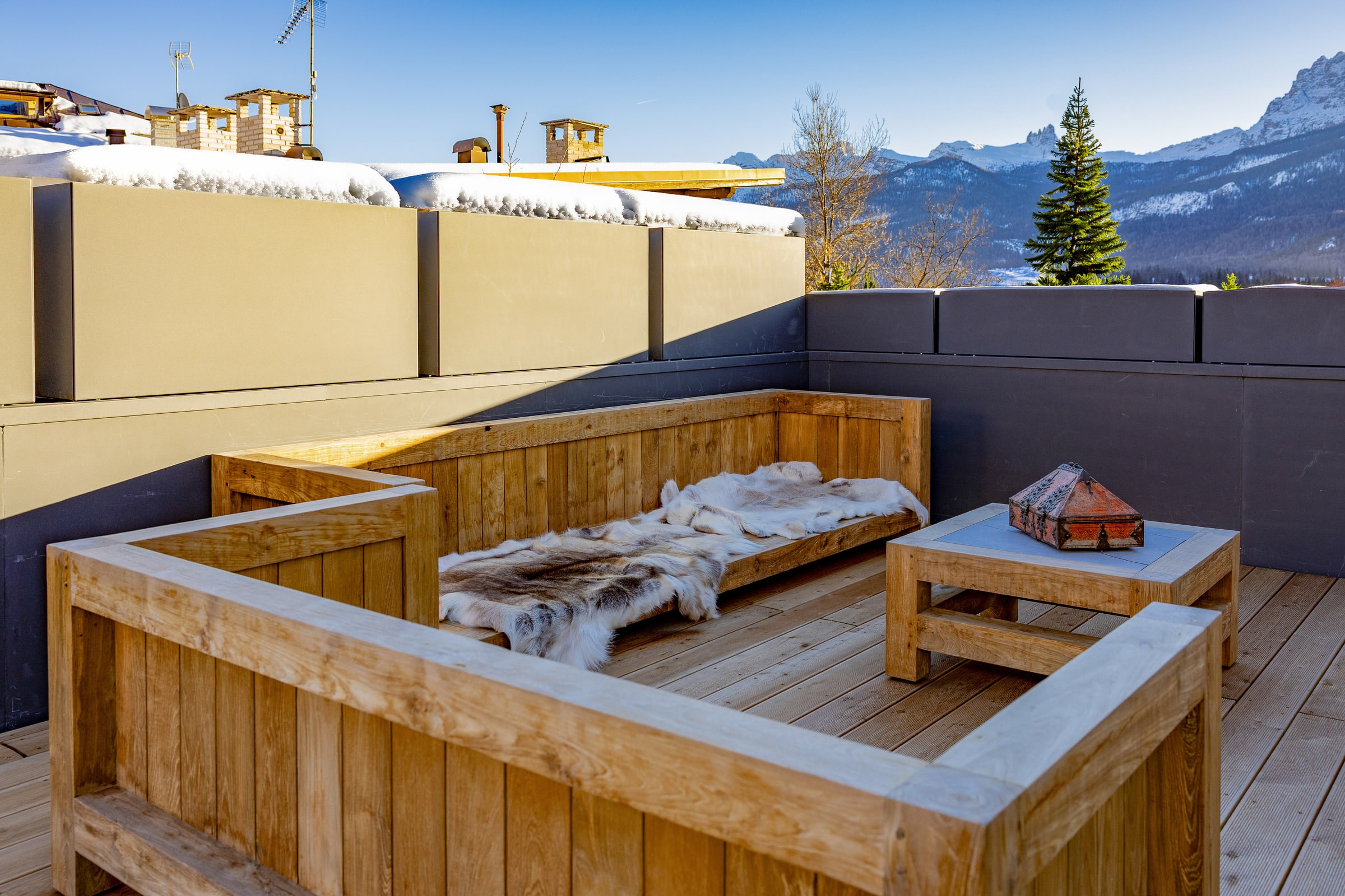Patio sotto la neve, sedie tirolesi e tetto innevato