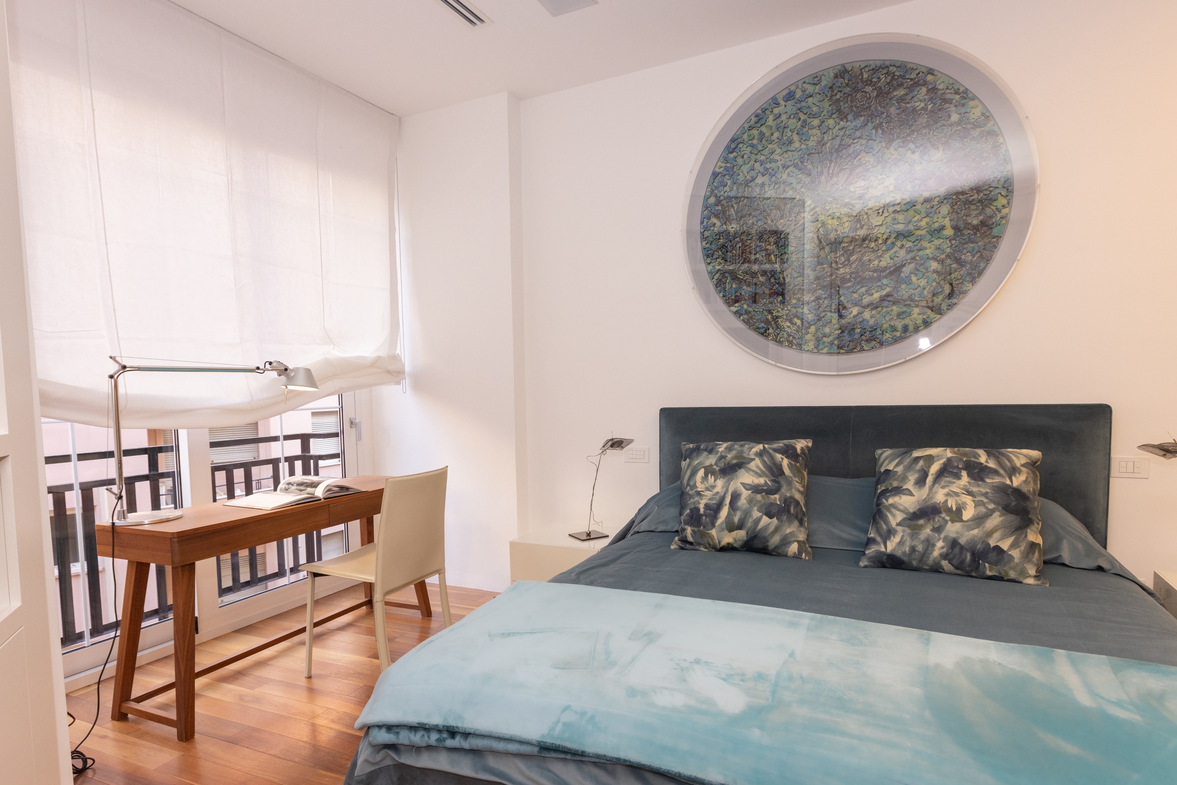 Camera padronale con scrittoio davanti alla finestra e mosaico sopra il letto