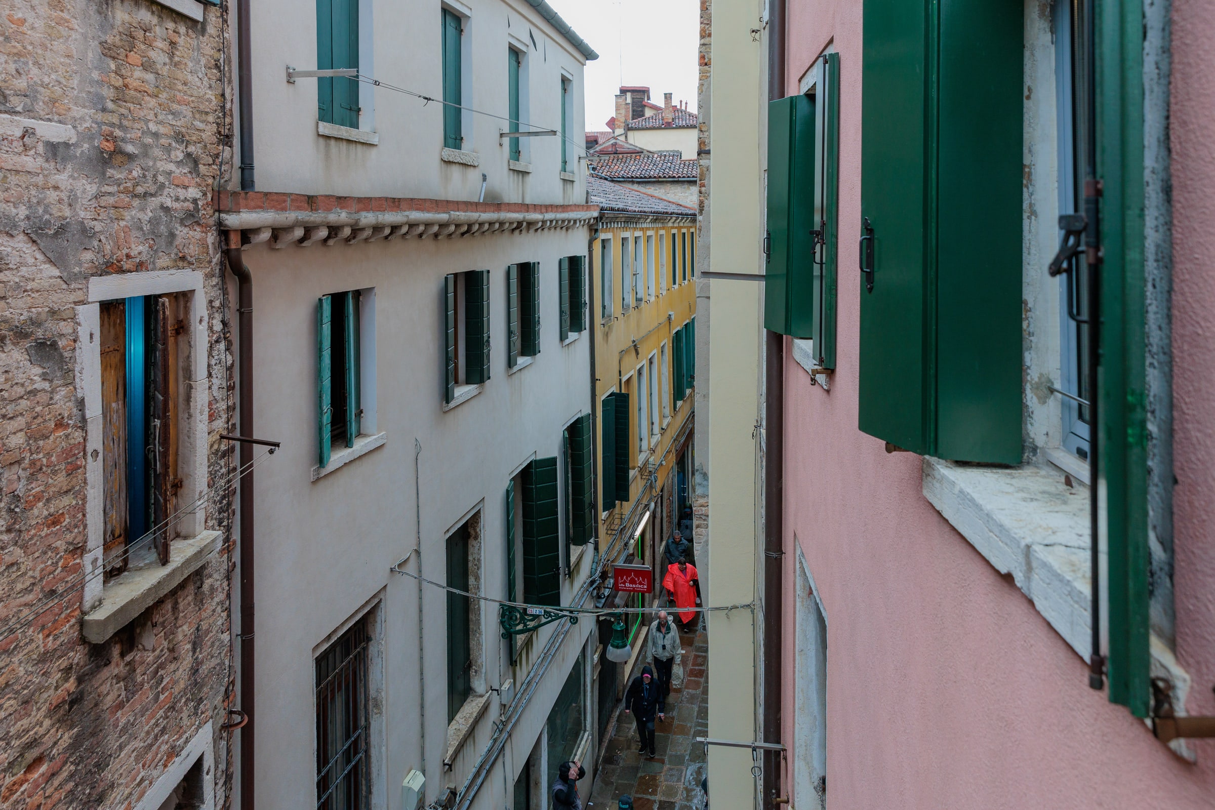 Vista da una finestra sulla calle veneziana, facciate rosa e terracotta