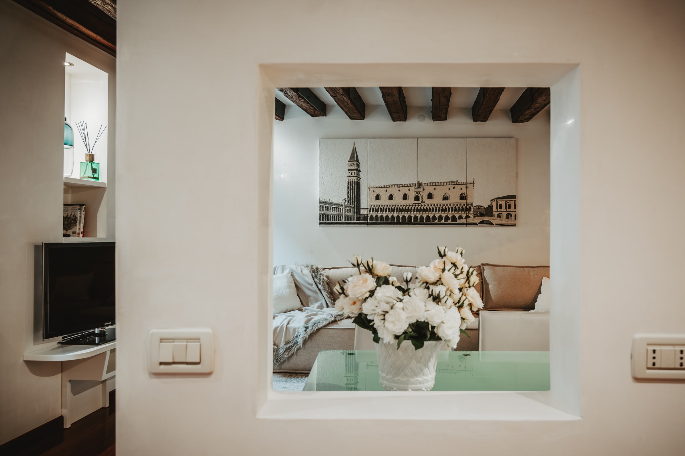 Salotto con travi a vista, divano ampio e stampa fotografica di San Marco — L'HOME Venezia